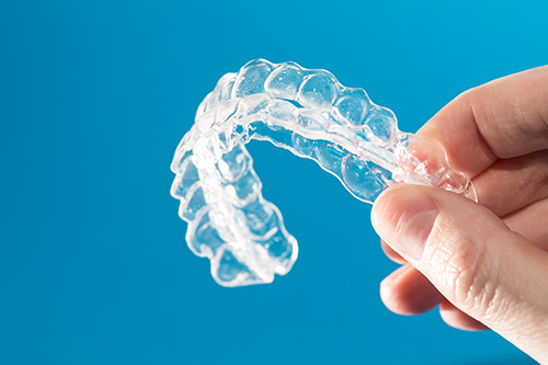Woman Holding Clear Aligners in Newcastle